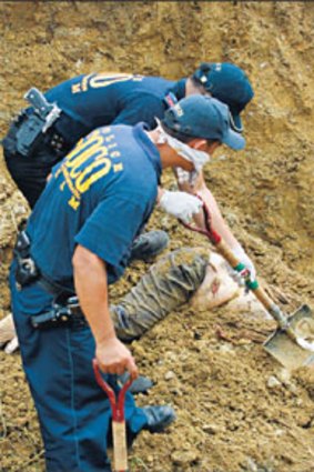 Police investigators dig for bodies of the victims of the massacre which were buried six layers deep on a hillside close to Ampatuan town.