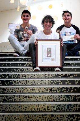 Harley Russo (centre) in 2014 aged 14 with his triplet brothers Cameron and Dylan. A combined family effort has seen Harley secure every first coin struck since 2013. But this year, the family is further down the line.



