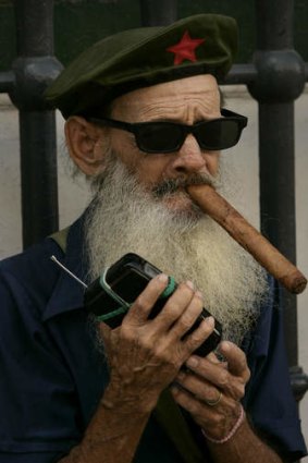 A cuban man enjoys his cigar as he listens to a portable radio in Havana.
