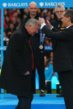 Sir Alex Ferguson receives his Premier League winners medal after the Premier League match between Manchester United and Swansea City on Sunday.