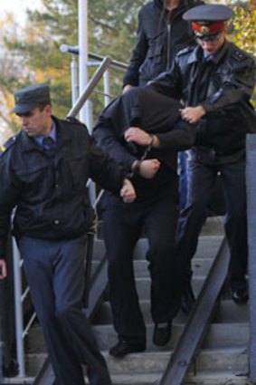 Police escort Sergei Tsepovyaz, a suspect in the killing of 12 people near Sochi.
