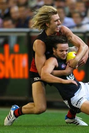 Essendon's Dyson Heppell wraps up Carlton's Dylan Buckley.