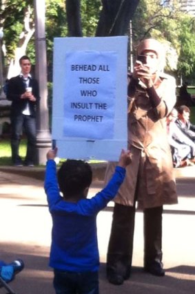 Safe ... a mother takes a photo of her boy holding up a sign at Saturday's Islamic protests in Sydney.