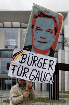 A demonstrator holds a sign supporting German politician Joachim Gauck as president.