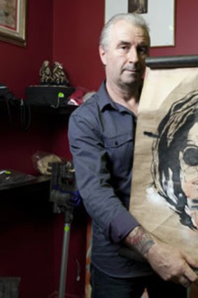 Antique And Fine Art Auctions principal auctioneer Stuart Vallance holds up a Jake Reston Spray Painted Scroll formerly owned by "fake prince" Joel Barlow.