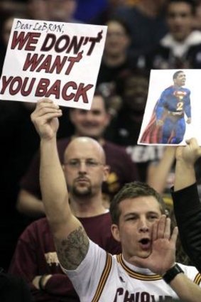 All is now forgiven .. a Cleveland Cavaliers fan holds a sign and yells as Miami Heat's LeBron James is introduced before a game against Cleveland in 2012.