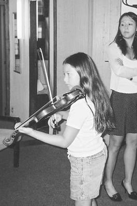Youngest daughter Lulu practises the violin under mum's eagle eye.