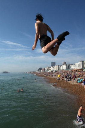 Reaching new heights &#8230; a youth jumps into the water from a sea wall in Brighton during late season high temperatures on Saturday.