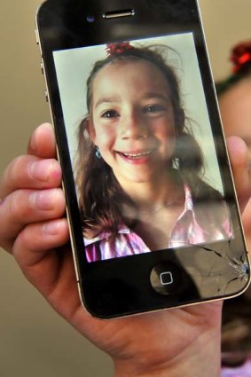 India Thomas shows the damage to her father's new iPhone when it was dropped on the road.