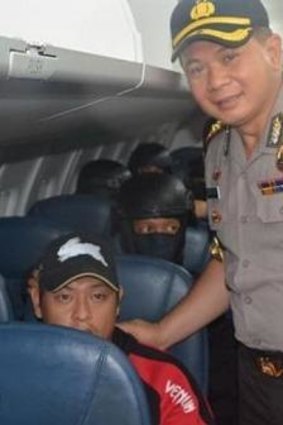 An Indonesian official poses for a photo with Bali Nine ringleader Andrew Chan on the flight from Bali to Cilacap.