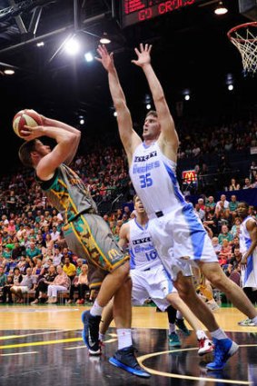Tall order: Brian Conklin of the Crocodiles attempts a jump shot over Alex Pledger of the Breakers.