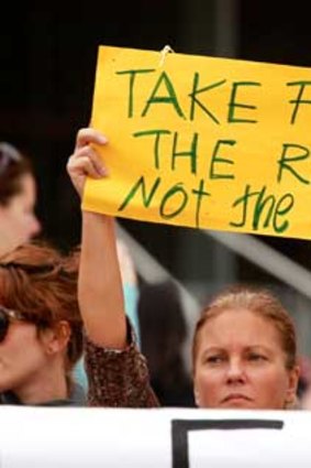 A single mother holds a placard at a rally on Saturday.