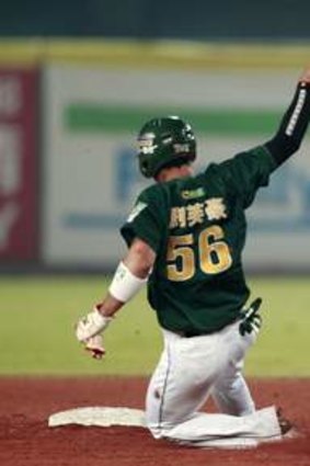 Base runner Liu Fu-hao (56) of Taiwan's Uni-President 7-Eleven Lions slides to second base while Shane Opitz of Australia's Canberra Cavalry waits during the third inning of the final of the Asia Series at Taichung Intercontinental Baseball Stadium November 20, 2013.