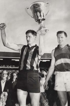 Hawthorn Skipper Graham Arthur holds aloft the 1961 premiership cup at Footscray's Ted Whitten looks on.