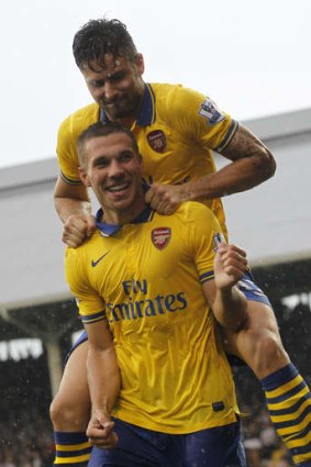 Lukas Podolski (bottom) celebrates his second goal against Fulham with teammate Olivier Giroud.