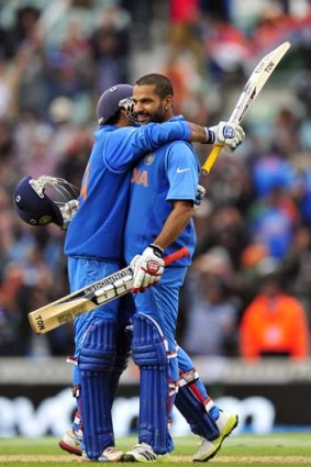 India's Shikhar Dhawan (R) celebrates his century with teammate Dinesh Karthik.