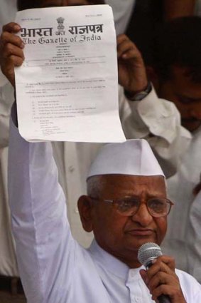 Indian activist Anna Hazare, 73, shows a government notiification to supporters after breaking his hunger strike.