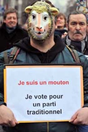 A protester in Brussels holds a sign that reads: "I am a sheep, I vote for the traditional party."