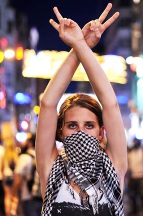 An anti goverment protester flashes a victory sign during the clashes between protestors and riot police on Taksim square in Istanbul.