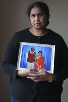 Sam Kumari Prasad holds a picture of her late husband, Arnuch.