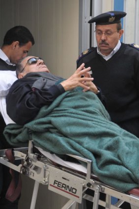 Former president Hosni Mubarak, lies on a stretcher as he leaves court following his trial in Cairo.