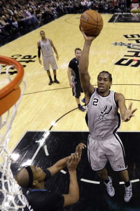 San Antonio Spurs forward Kawhi Leonard shoots over Minnesota Timberwolves opponent Dante Cunningham.