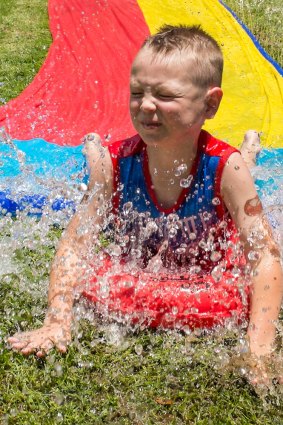 Six-year-old Callan Dunstan enjoying the waterslide at a family party in Gordon.