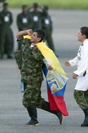 Finally free ... army sergeant Luis Alfredo Moreno waves a Colombian flag on arrival at an airport after being released yesterday.