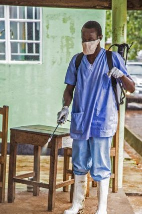 A health worker sprays disinfectant against the deadly Ebola virus at the Kenema Government Hospital in Sierra Leone on Saturday.