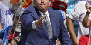 Ron DeSantis throws hats to the crowd before a campaign rally by then president Donald Trump in 2020.
