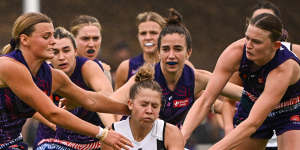 J’Noemi Anderson is tackled by a group of Dockers.