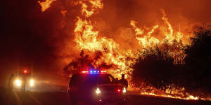 Flames lick above vehicles on Highway 162 as the Bear Fire burns in Oroville,California.