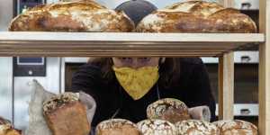 Jamie Goodin filling shelves with rustic miche and fruit loaves.