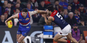 Marcus Bontempelli attempts to evade a tackle by Christian Petracca.