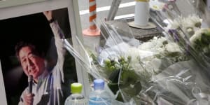 Flowers,bottles of water and a framed photograph of former Japanese prime minister Shinzo Abe rest in a makeshift shrine near the crime scene in Nara on Saturday.