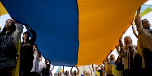 People hold a Ukrainian flag in Buenos Aires,Argentina on Saturday to mark the second anniversary of Russia’s invasion of Ukraine.