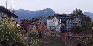 Villagers stand in front of their damaged houses from the earthquake in Jagarkot,Nepal,on Saturday.