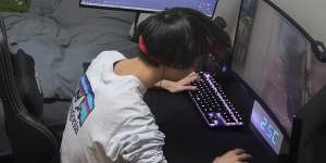 Wataru Yoshida,who started going to Japan’s first eSports high school after dropping out of school during the pandemic,plays games at home in Tokyo.
