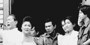 Ferdinand Marcos,with his wife Imelda at his side and Ferdinand Marcos jr,far right,gestures from the balcony of Malacanang Palace on February 25,1986 in Manila,just after taking the oath of office as president of the Philippines. 