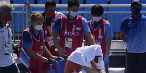 Spain’s Paula Badosa is helped off the court in a wheelchair in Tokyo.