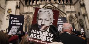 A demonstrator holds a placard calling for the release of Julian Assange outside the Royal Courts of Justice in London on Tuesday.