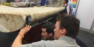 Australian Transport Safety Bureau staff examine a piece of aircraft debris found off the coast of Tanzania at their laboratory in Canberra last year.