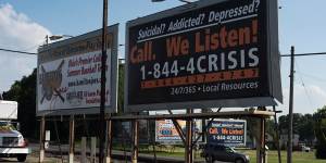 Billboards stand along the side of the road and in a parking lot advertising a local crisis hotline in Hamilton,Ohio. 