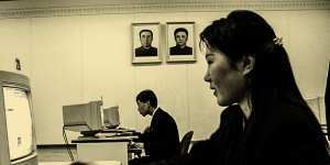 Students engage in a simulated internet chat in the Grand People’s Study House in Pyongyang,under portraits of Kim Il-Sung and his son,KIm Jong-il.