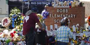 People pay their respects at a memorial outside Robb Elementary School to honour the victims killed in the school shooting in Uvalde,Texas.