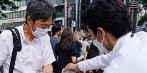A seller hands an extra edition of the news of the attack on Shinzo Abe,in Tokyo on Friday.