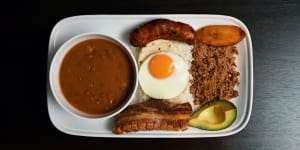 Bandeja paisa platter with braised red beans,chicharron (fried pork belly),minced beef,Colombian chorizo,plantain,avocado,arepa,fried egg and rice.