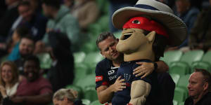Game over . . . a fan hugs the Melbourne Rebels mascot.