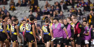 Richmond players gather around Sam Banks before he was driven off the ground.