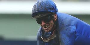 James McDonald grins through the mud after winning the Champagne Stakes on Broadsiding.